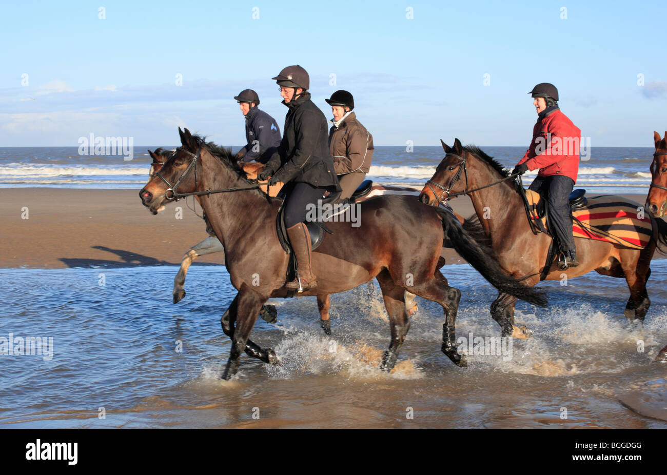 Quatre cavaliers sur la plage Équitation à Burnham Overy de Holkham le jour de l'an 2010. Banque D'Images