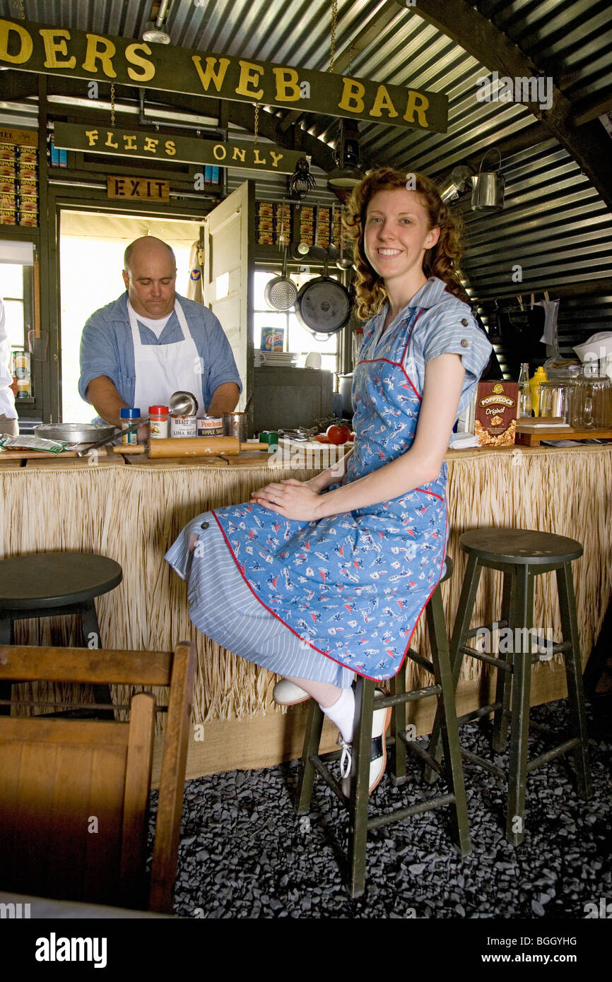 1940 acteur vêtu de vêtements vintage se trouve dans la deuxième guerre mondiale, un bar de style dans le Pacifique Sud au centre du littoral de l'Air Museum Banque D'Images