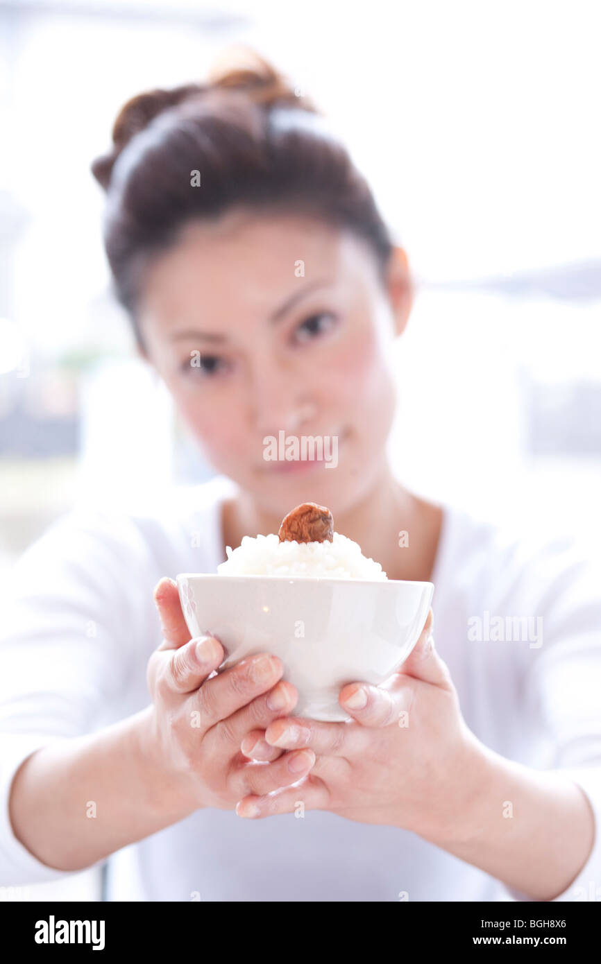 Jeune femme à la Table portant bol de riz de l'avant Banque D'Images