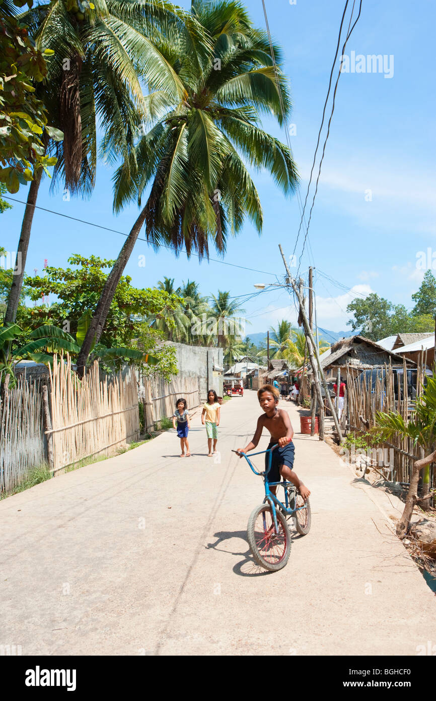 Garçon sur un vélo ; ville ; l'Île Coron Busuanga, Philippines Banque D'Images