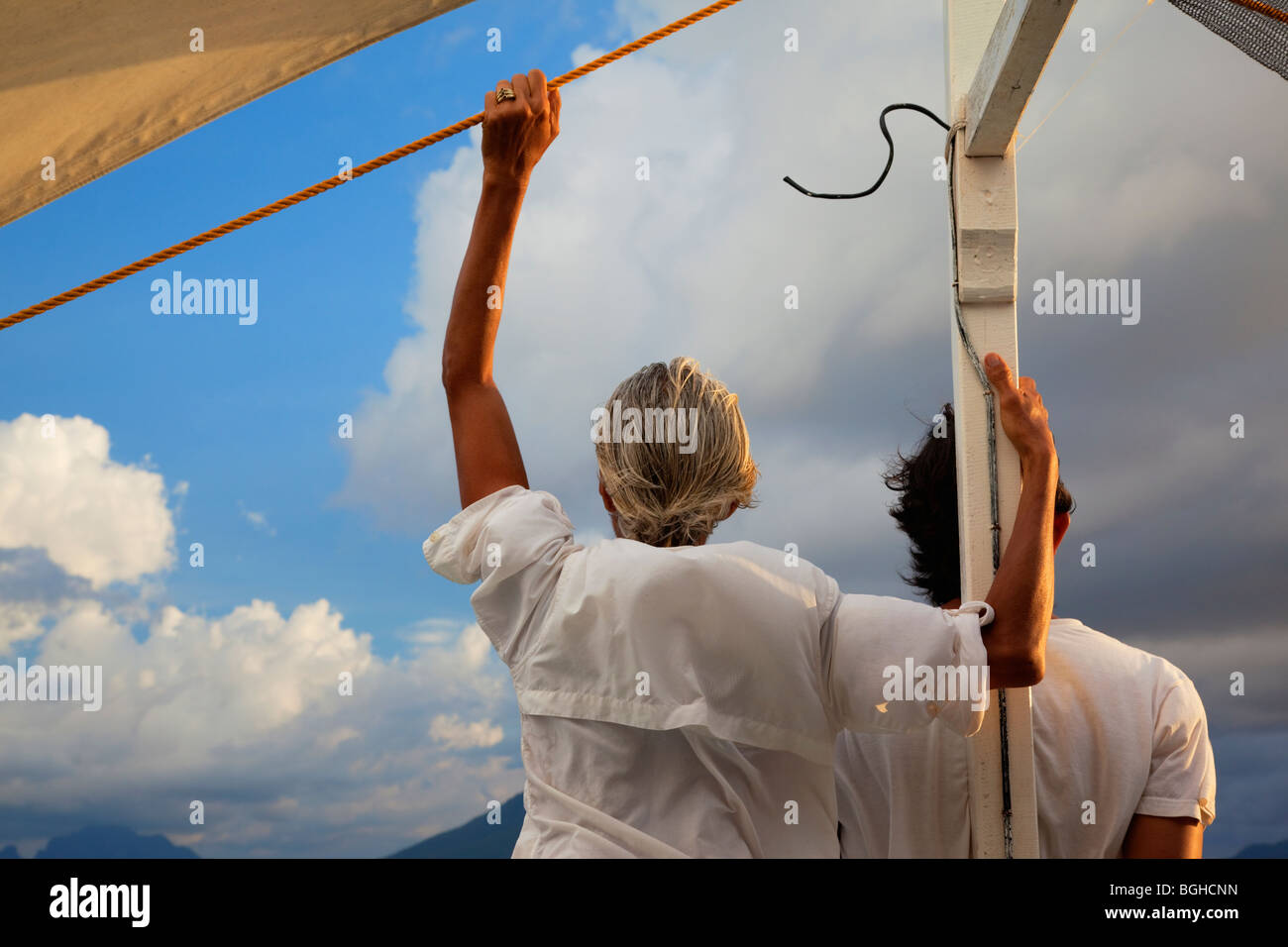 Deux personnes à la recherche vers l'horizon de l'avant d'un bateau, Palawan, Philippines. Banque D'Images