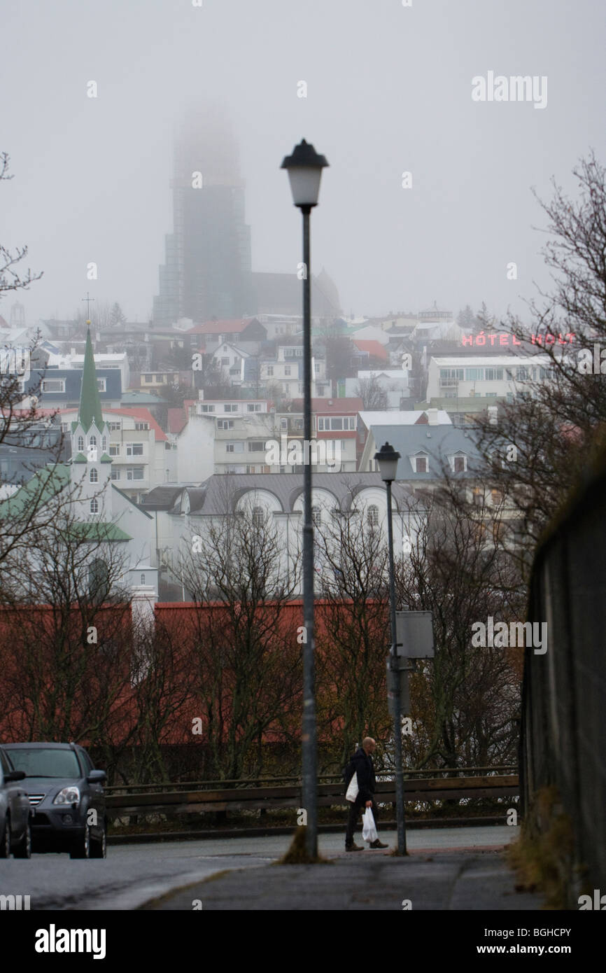 Les gens marcher pendant un jour pluvieux et brumeux. L'église Hallgrimskirkja en arrière-plan. Le centre-ville de Reykjavik, Islande. Banque D'Images