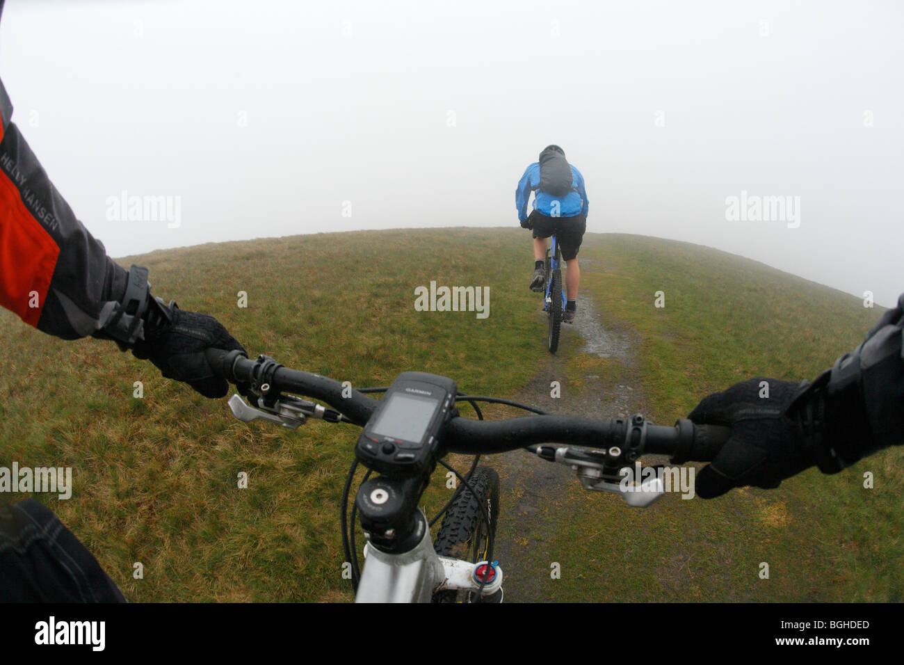Deux cyclistes de montagne monter un sentier brumeux à Fells Cap Sud, Royaume-Uni Banque D'Images