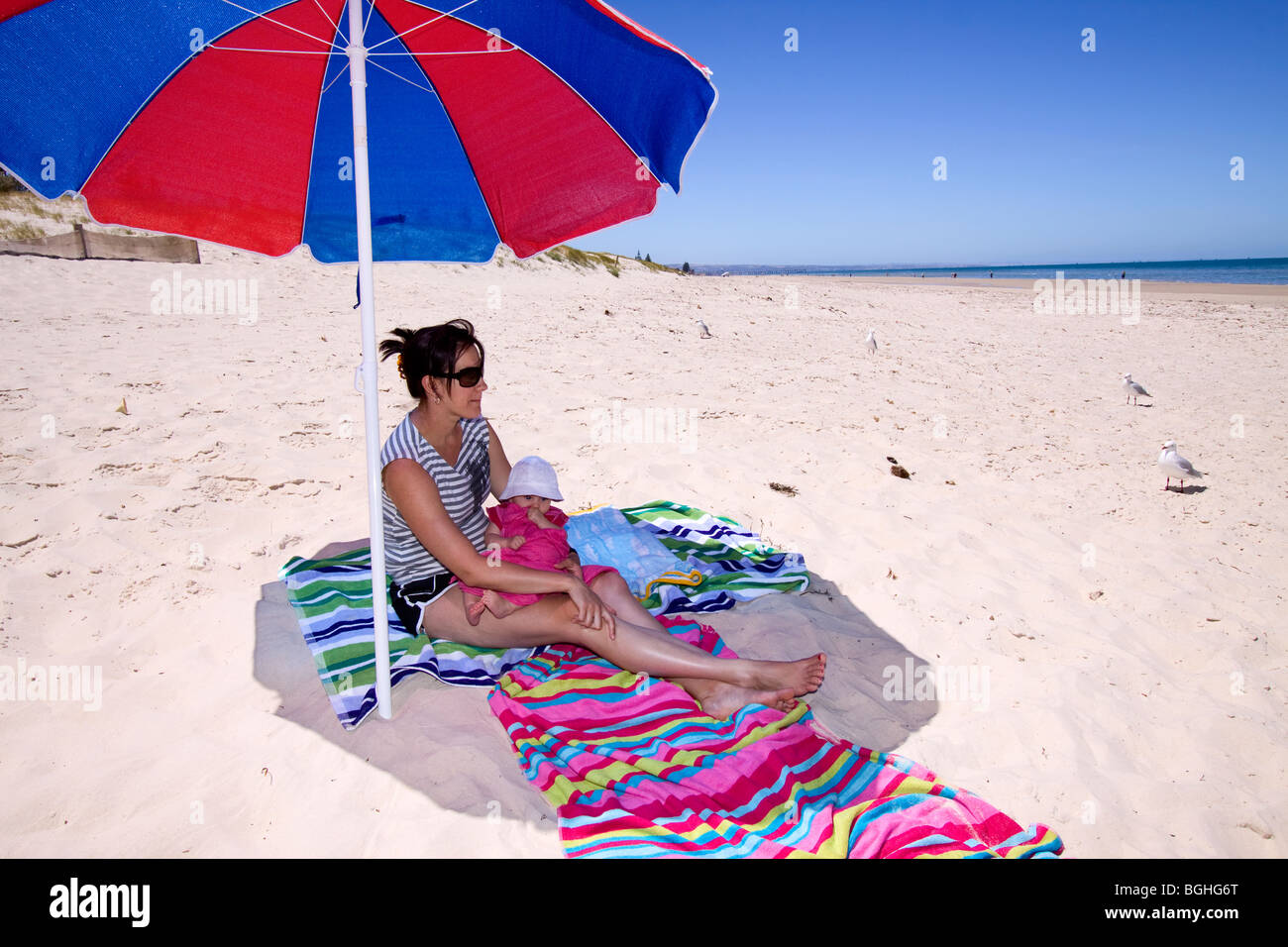 Femme Et Bebe Assis Sous Un Parasol A La Plage Photo Stock Alamy