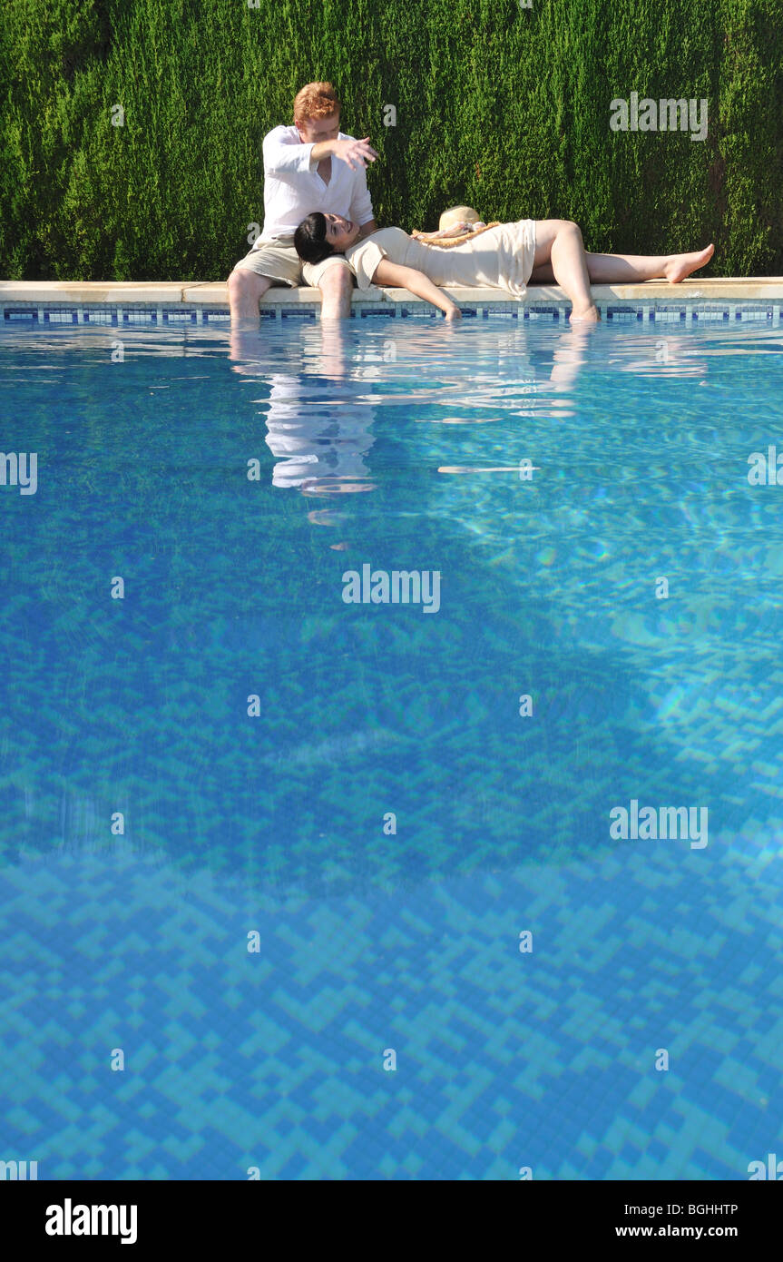 Jeune couple au bord de la piscine Banque D'Images