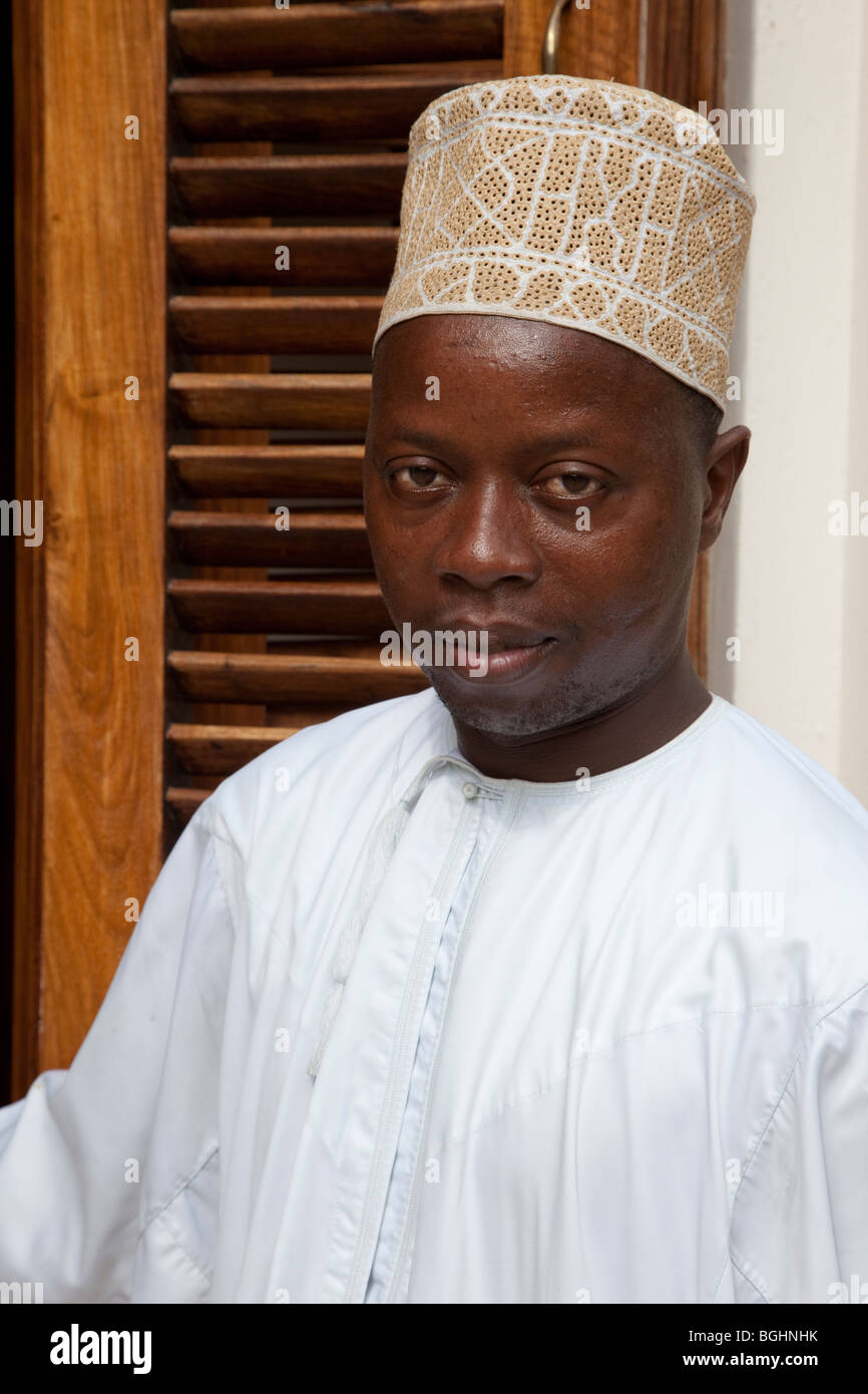 Zanzibar, Tanzanie. Zanzibari africaine portant une kanzu blanc traditionnel et un chapeau traditionnel, un kofia. Banque D'Images