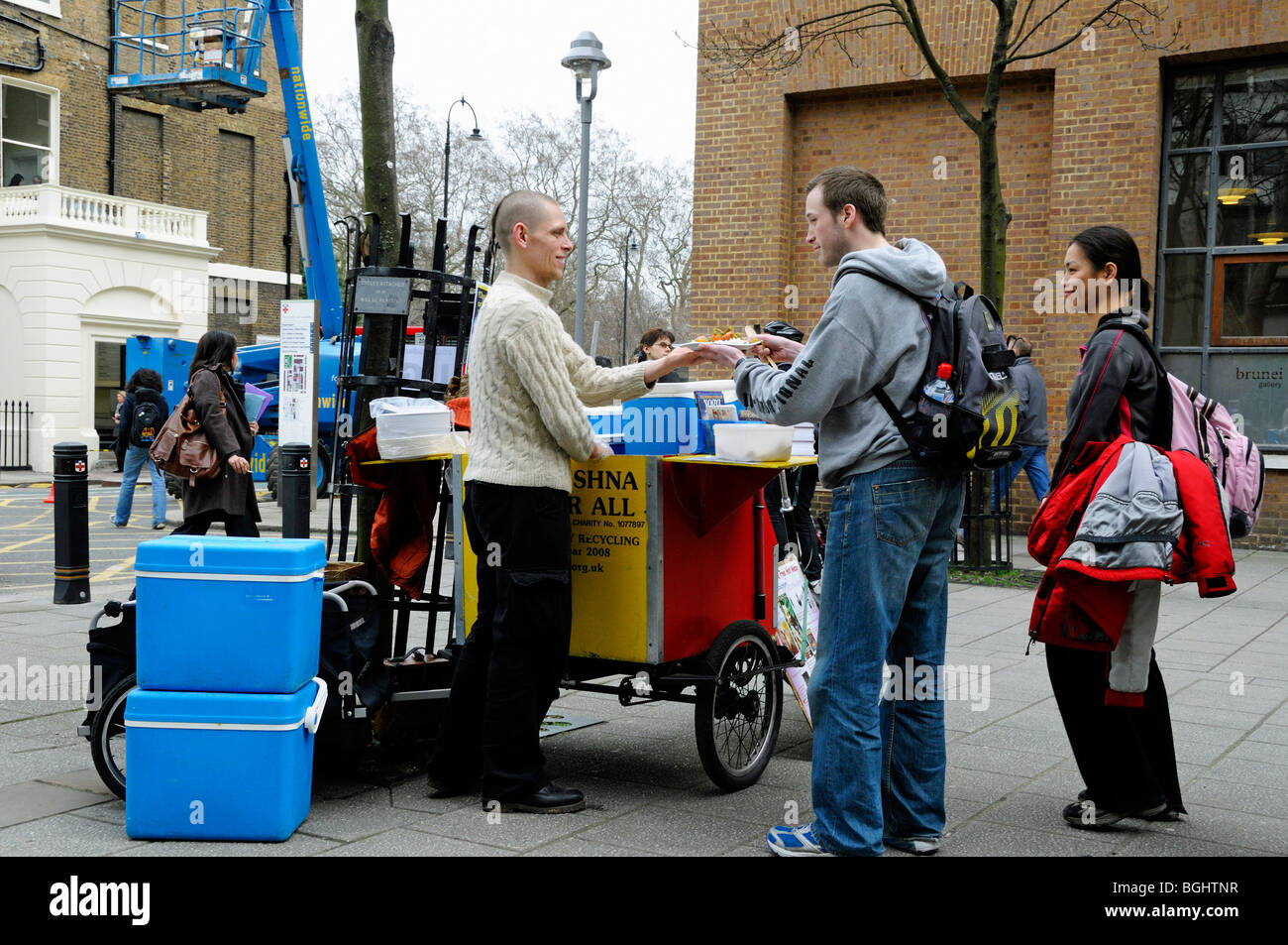 L'homme depuis le mouvement Hare Krishna servant de la nourriture gratuite pour les étudiants et les passants par London England UK Banque D'Images