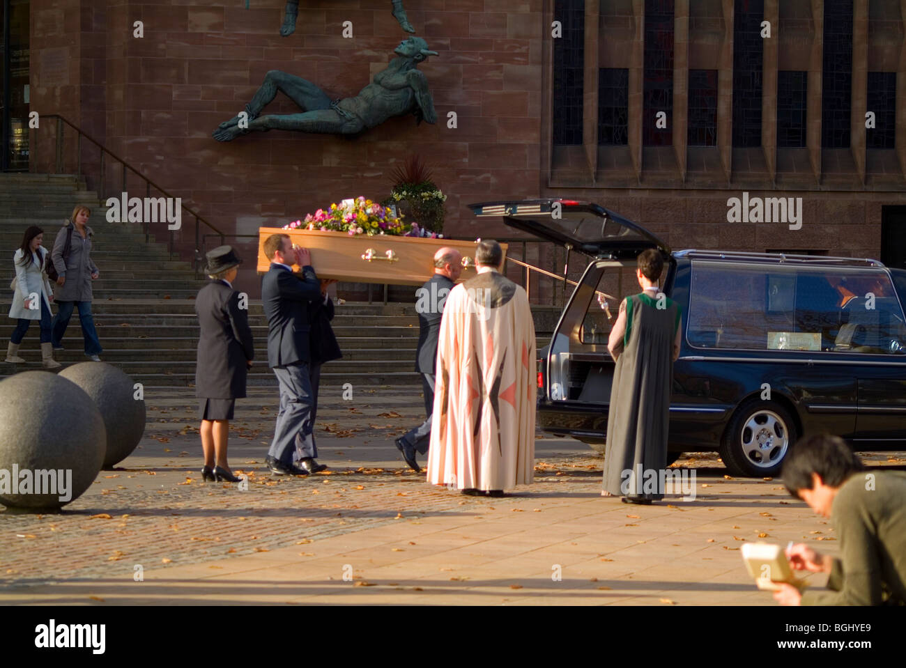 Un cercueil d'être chargés à bord d'un corbillard à l'extérieur de la cathédrale de Coventry. Banque D'Images