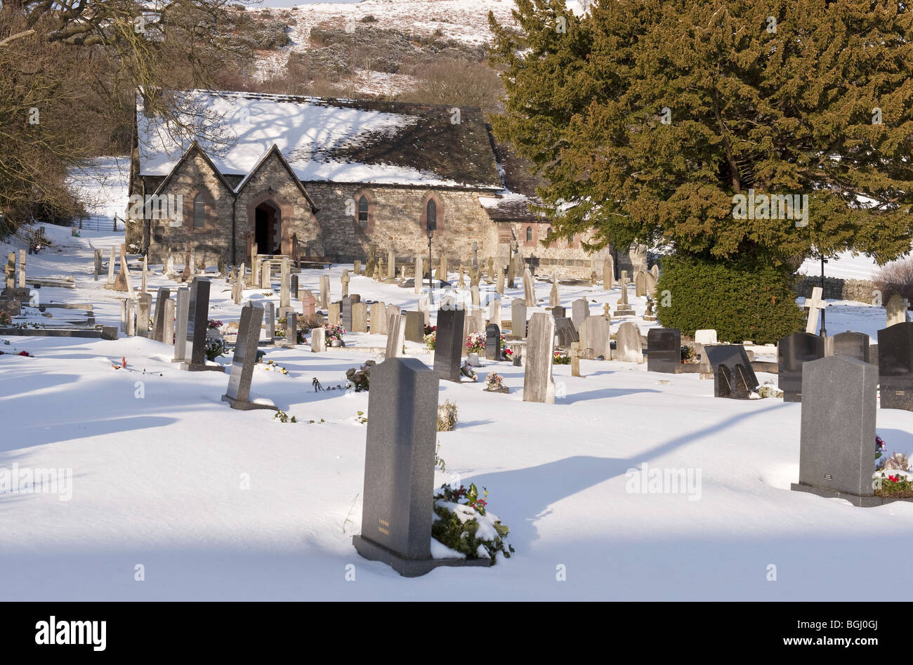La neige a couvert petit village church et cimetière en milieu rural Banque D'Images