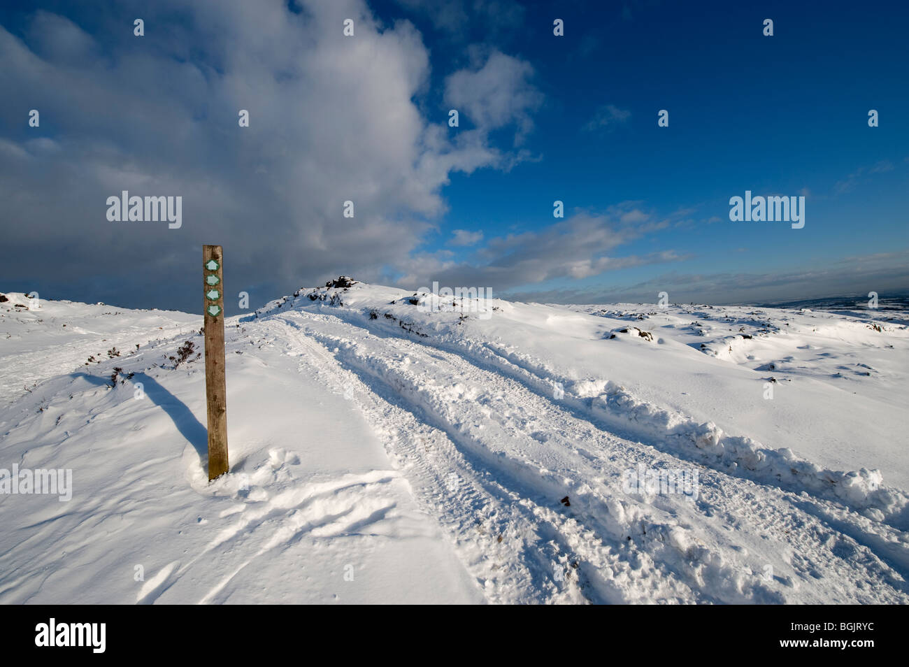 Des pistes sur un véhicule bridleway et sentier du panneau directionnel sur la lande en hiver Banque D'Images