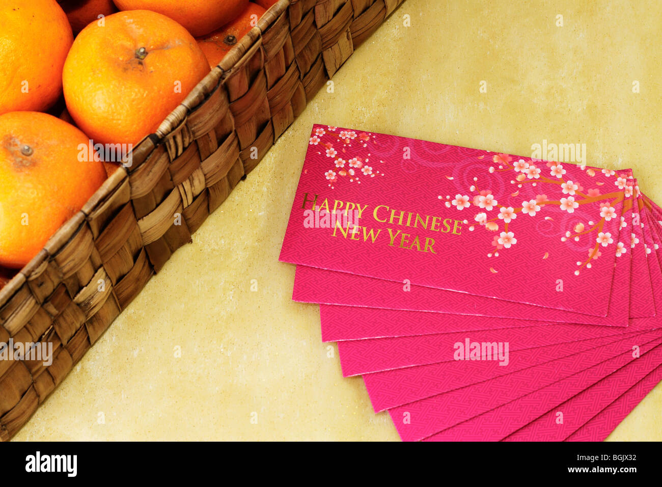 Paquets d'argent du Nouvel An chinois avec une boîte de mandarines par le côté Banque D'Images