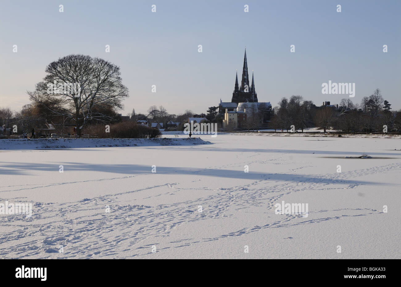 Trois spires cathédrale et Stowe congelé avec des empreintes de l'autre côté de la piscine on snowy winter's day 2010 Angleterre Lichfield Banque D'Images