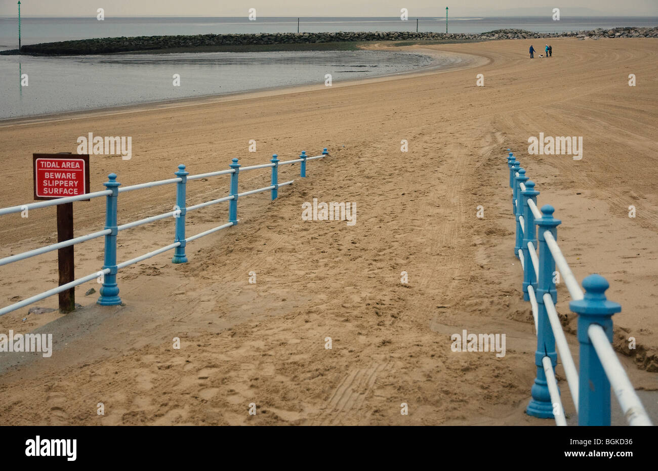 Plage de Morecambe avec retraités walking dogs in distance Banque D'Images