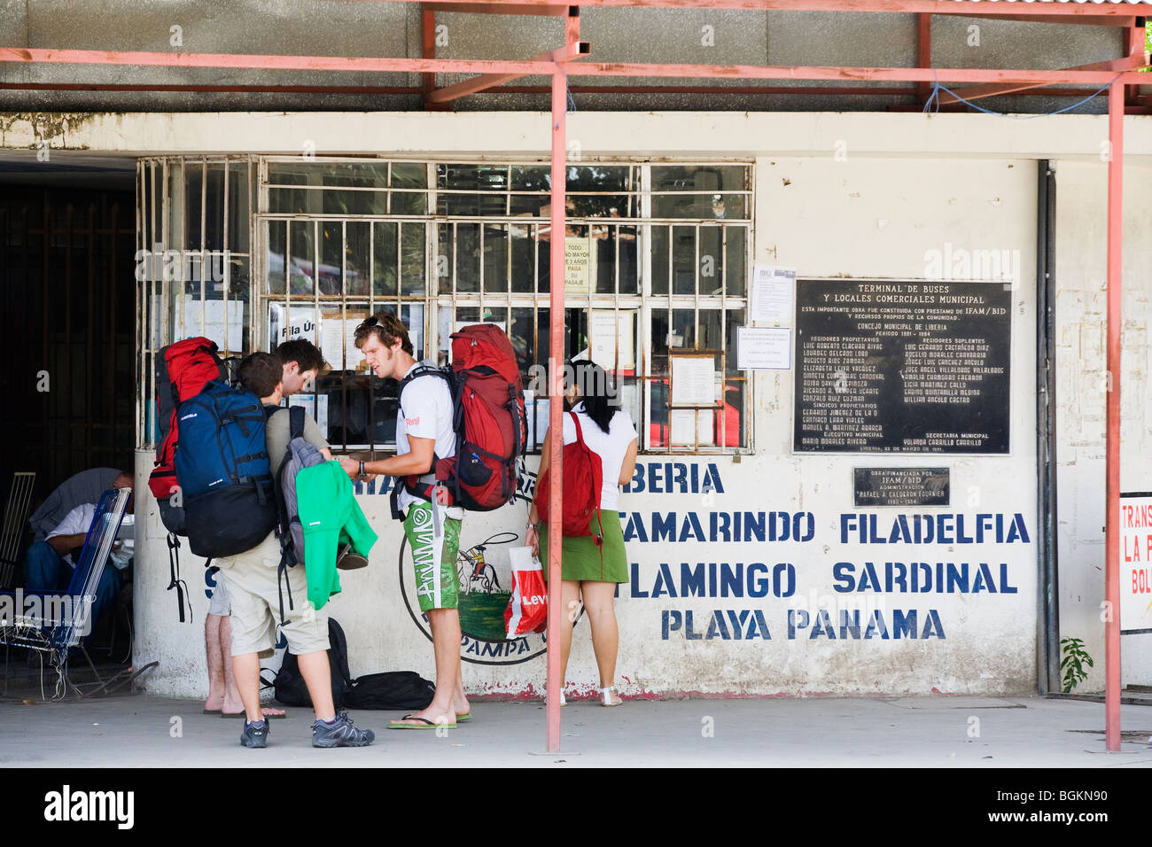 Un groupe de backpackers d'acheter un ticket de bus pour les plages de Guanacaste à partir de la station au Liberia, Costa Rica Banque D'Images