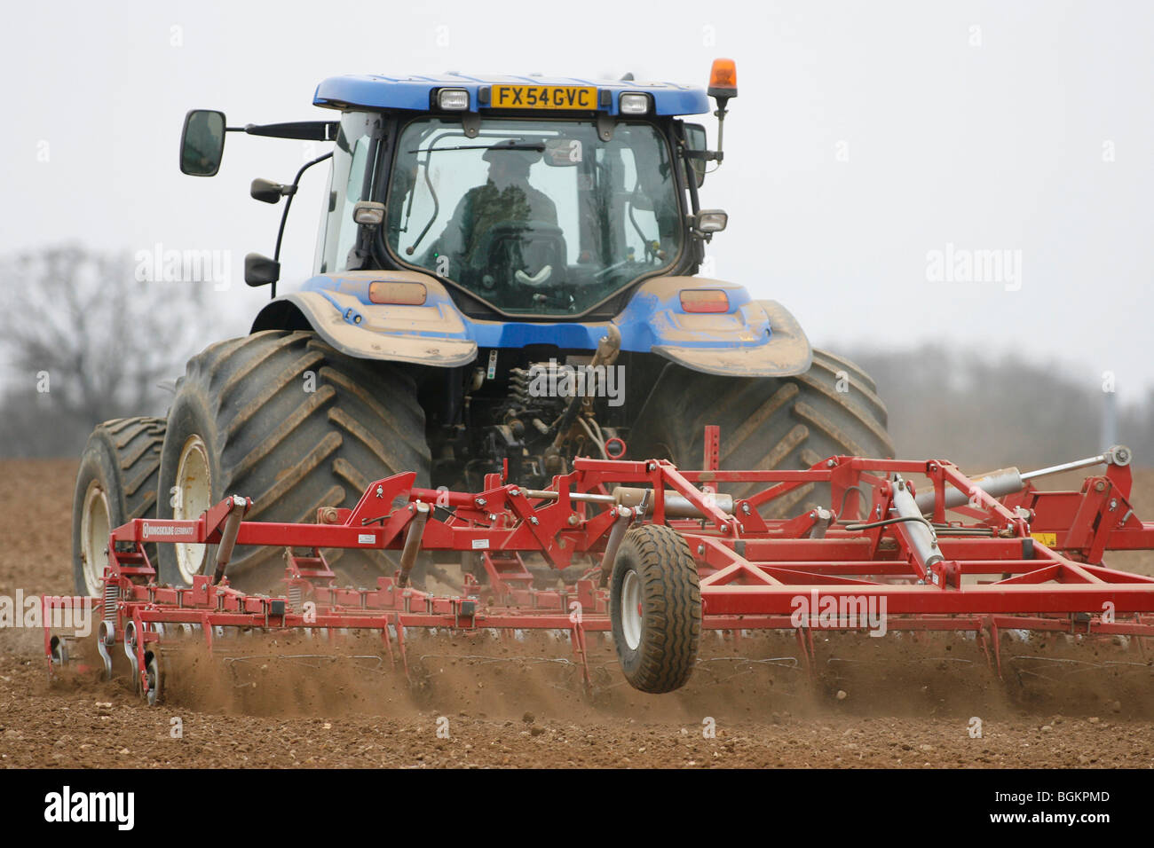 Tracteur New Holland cultivant la terre prête pour la récolte de l'année prochaine de forage Banque D'Images