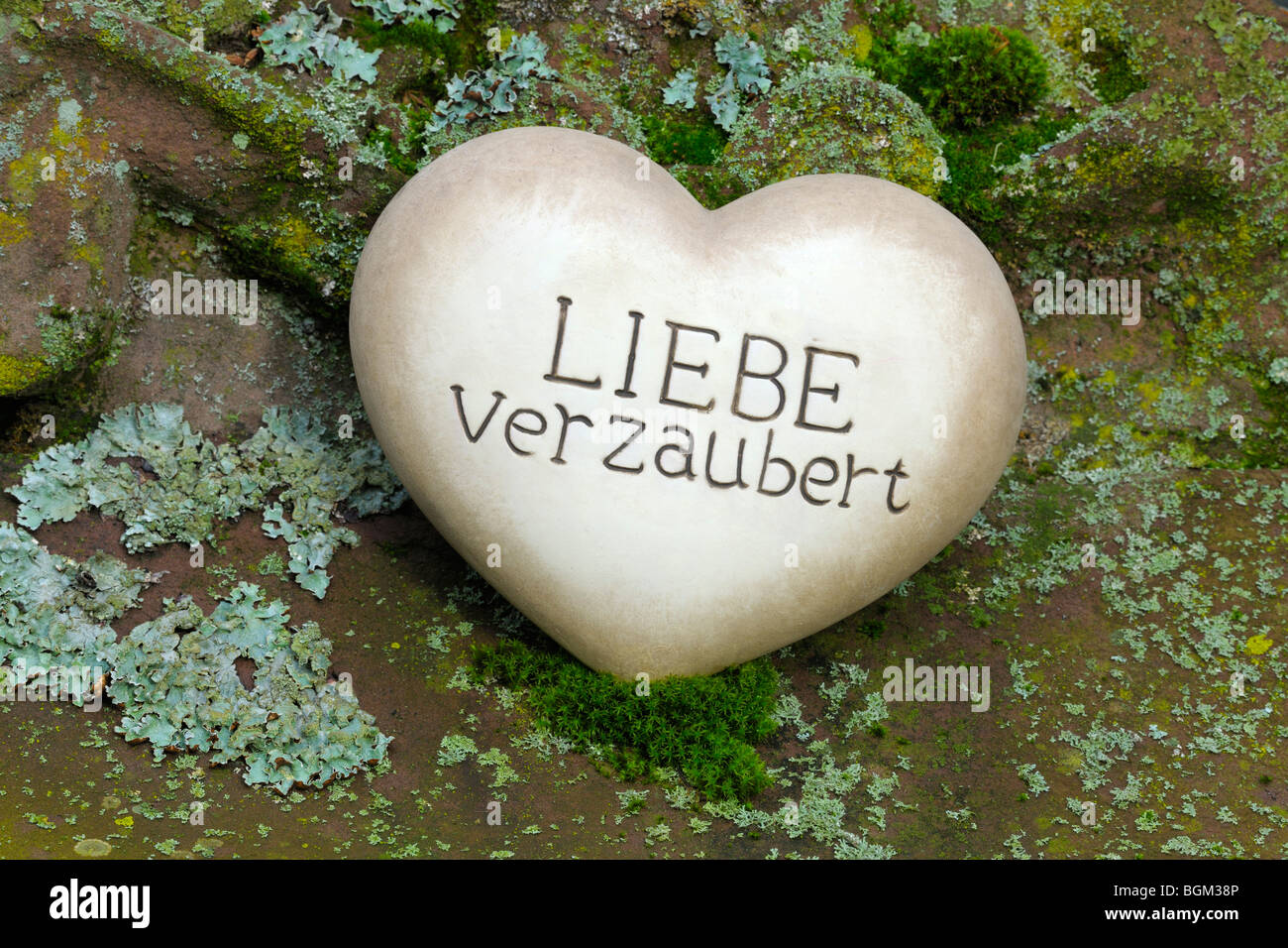 Coeur de pierre avec les mots 'Liebe verzaubert', l'allemand pour 'Amour' enchante Banque D'Images
