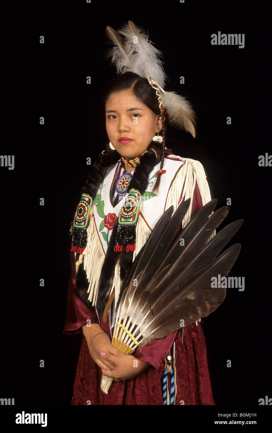 Teenage girl habillé en robe de peau tannée cerveau décoré de motifs perlés avec Native American flute en bois Banque D'Images