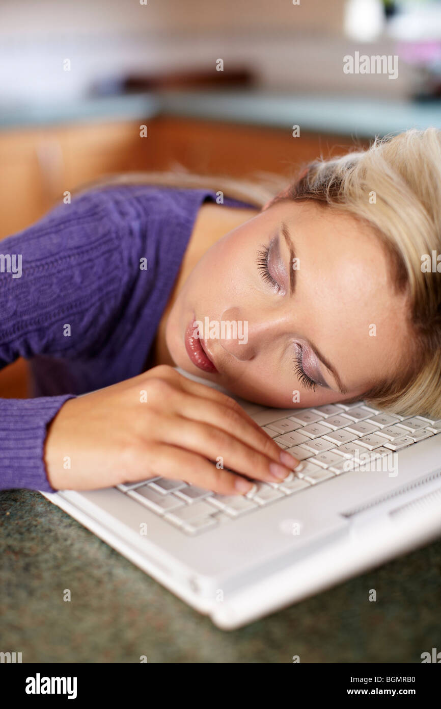 Jeune fille endormie sur l'ordinateur portable Banque D'Images