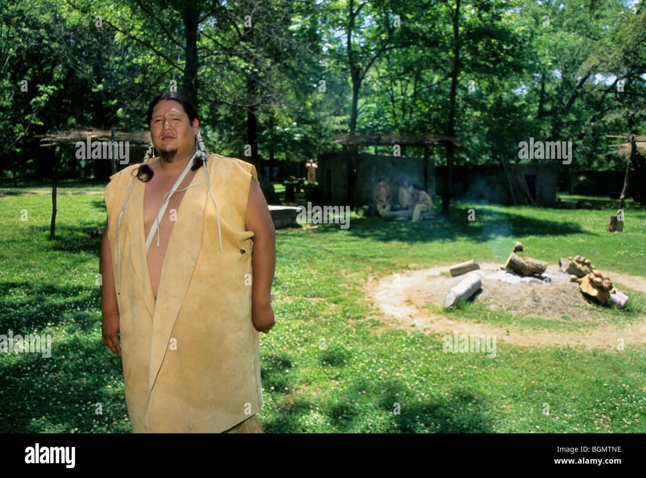 Cherokee homme vêtu de vêtements de daim traditionnel raconte des histoires de son peuple près du feu éternel dans Tahlequay OK. Banque D'Images