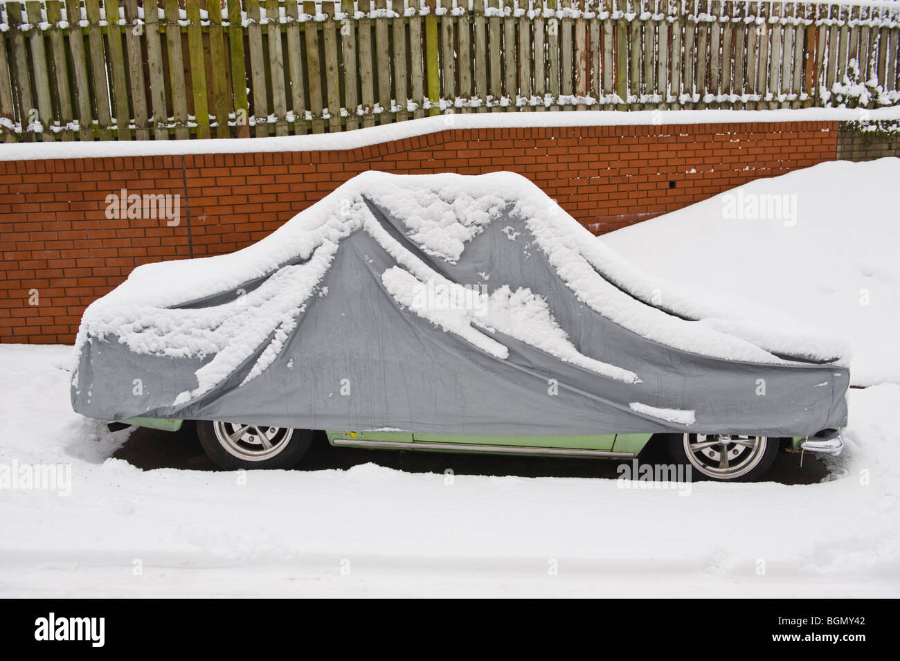 VW voiture classique avec cache de protection recouverte de neige à Newport South Wales UK Banque D'Images