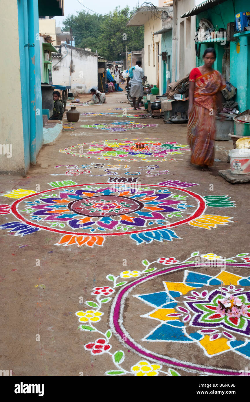 L'Inde femme faisant un rangoli design dans un Indian street , pendant le festival hindou de Sankranthi. Puttaparthi, Andhra Pradesh, Inde Banque D'Images