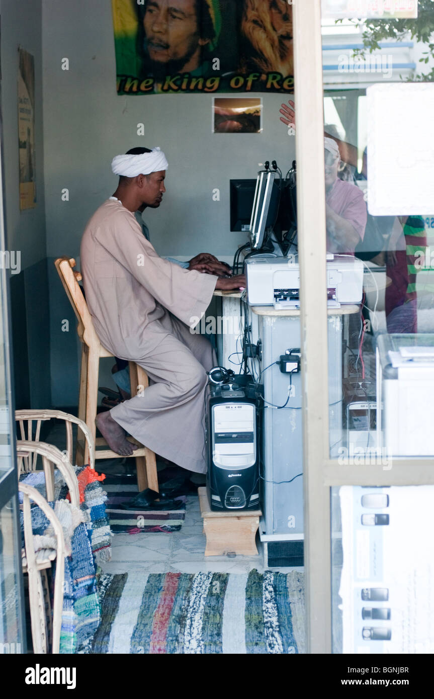 Jeune homme égyptien en turban travaillant sur un ordinateur dans un café internet. Banque D'Images