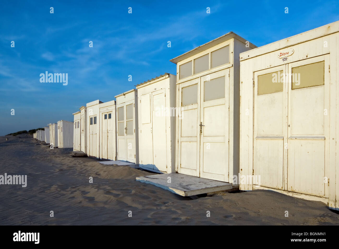 Rangée de cabines de plage de sable blanc le long de la côte de la mer du Nord à la station balnéaire / Coxyde Koksijde, Flandre occidentale, Belgique Banque D'Images