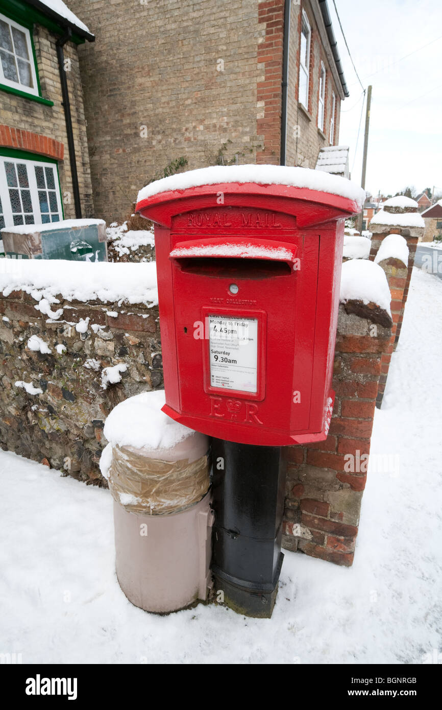 Boite aux lettres rouge couverte de neige en hiver, Ashley village près de Newmarket, Cambridgeshire UK Banque D'Images