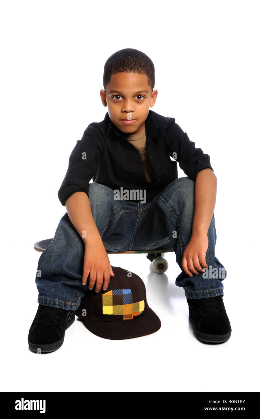Young African American boy sitting on skateboard isolated over white Banque D'Images