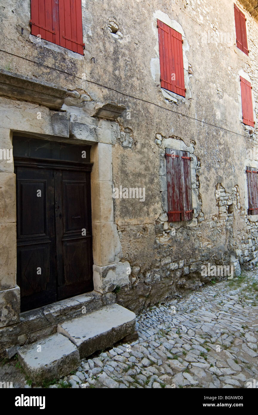 Vieilles maisons traditionnelles en bois rouge avec stores / volets en alley à Banon, Alpes de Haute Provence, Provence, France Banque D'Images