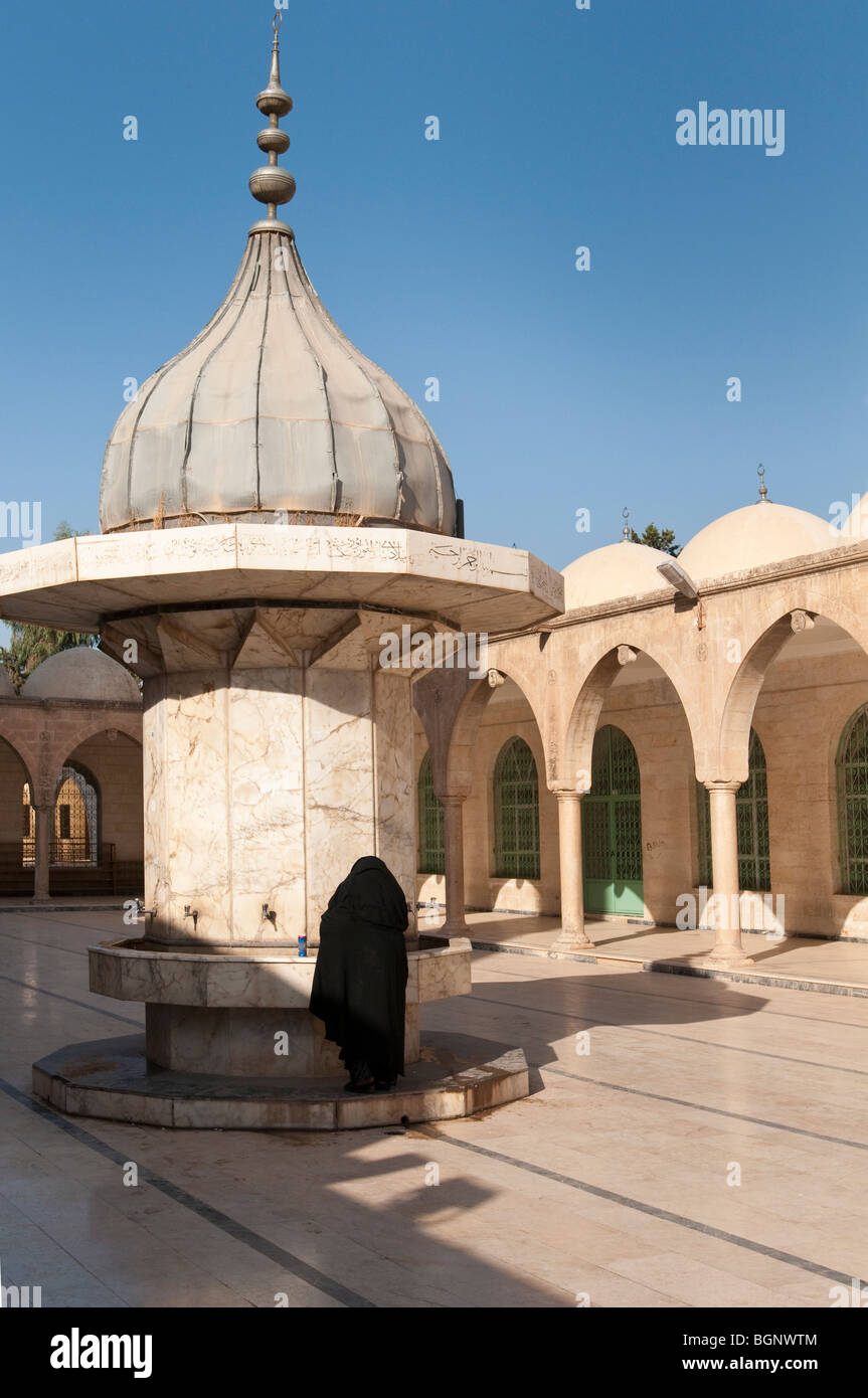 Une femme se lave les mains dans la préparation à la prière au complexe de mosquées, Dergah Urfa, Turquie Banque D'Images
