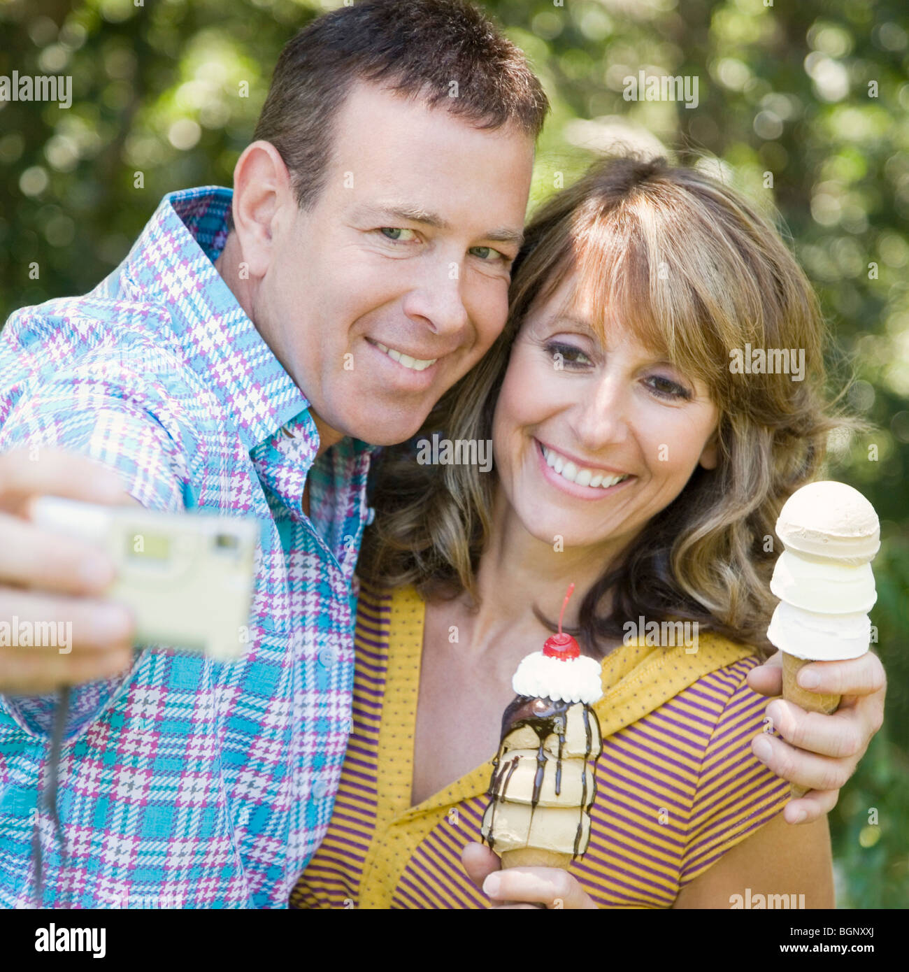 Close-up of a young couple holding ice cream cones et prendre une photo d'eux-mêmes Banque D'Images