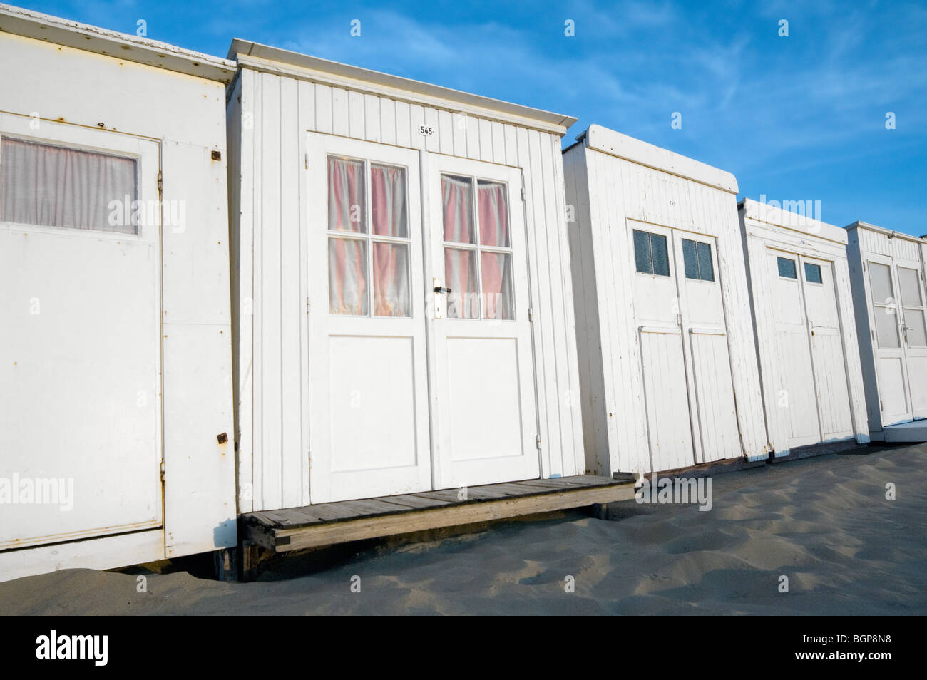Rangée de cabines de plage de sable blanc le long de la côte de la mer du Nord à la station balnéaire / Coxyde Koksijde, Flandre occidentale, Belgique Banque D'Images