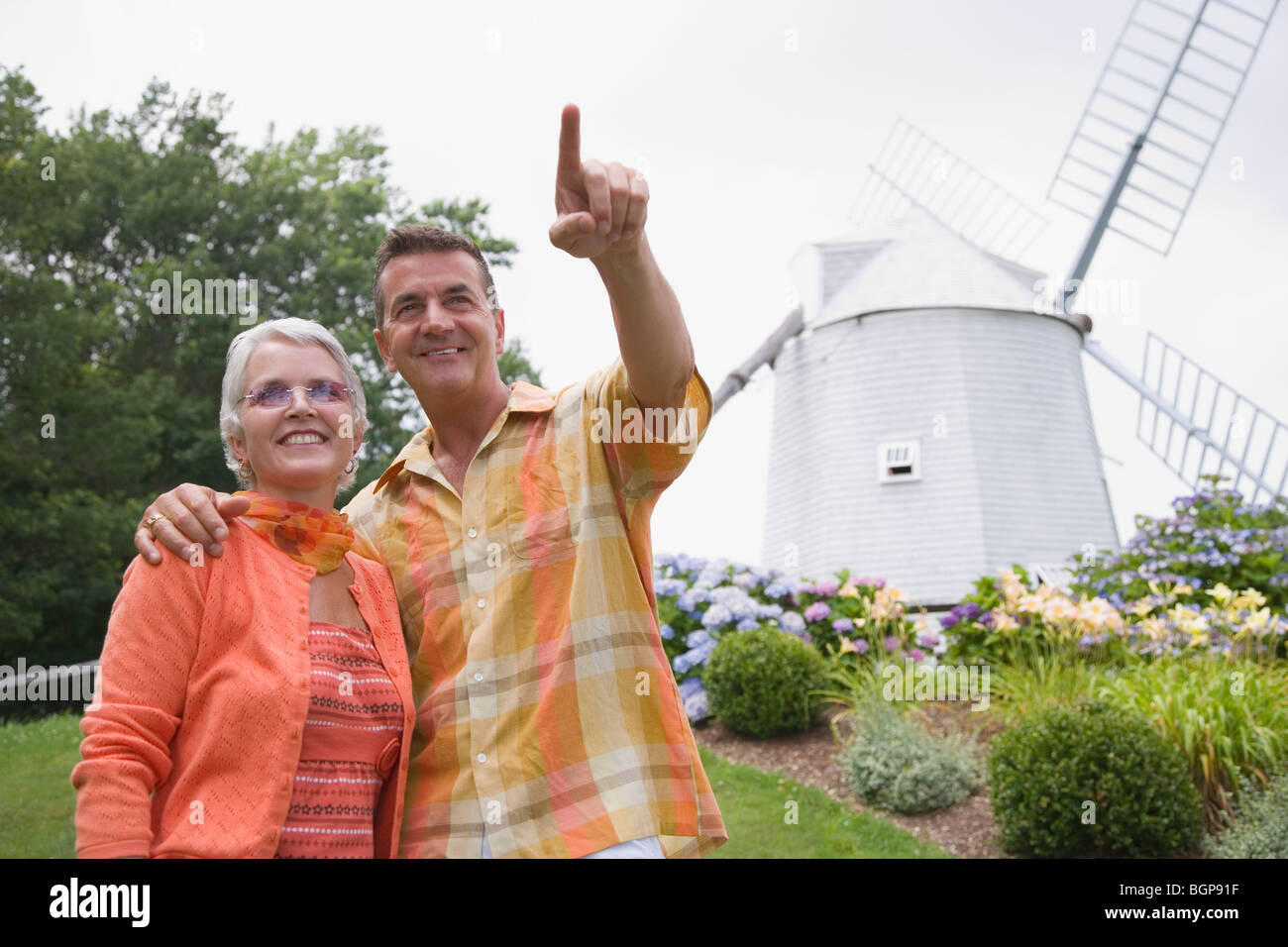 Couple mature en face d'un moulin dans un parc Banque D'Images