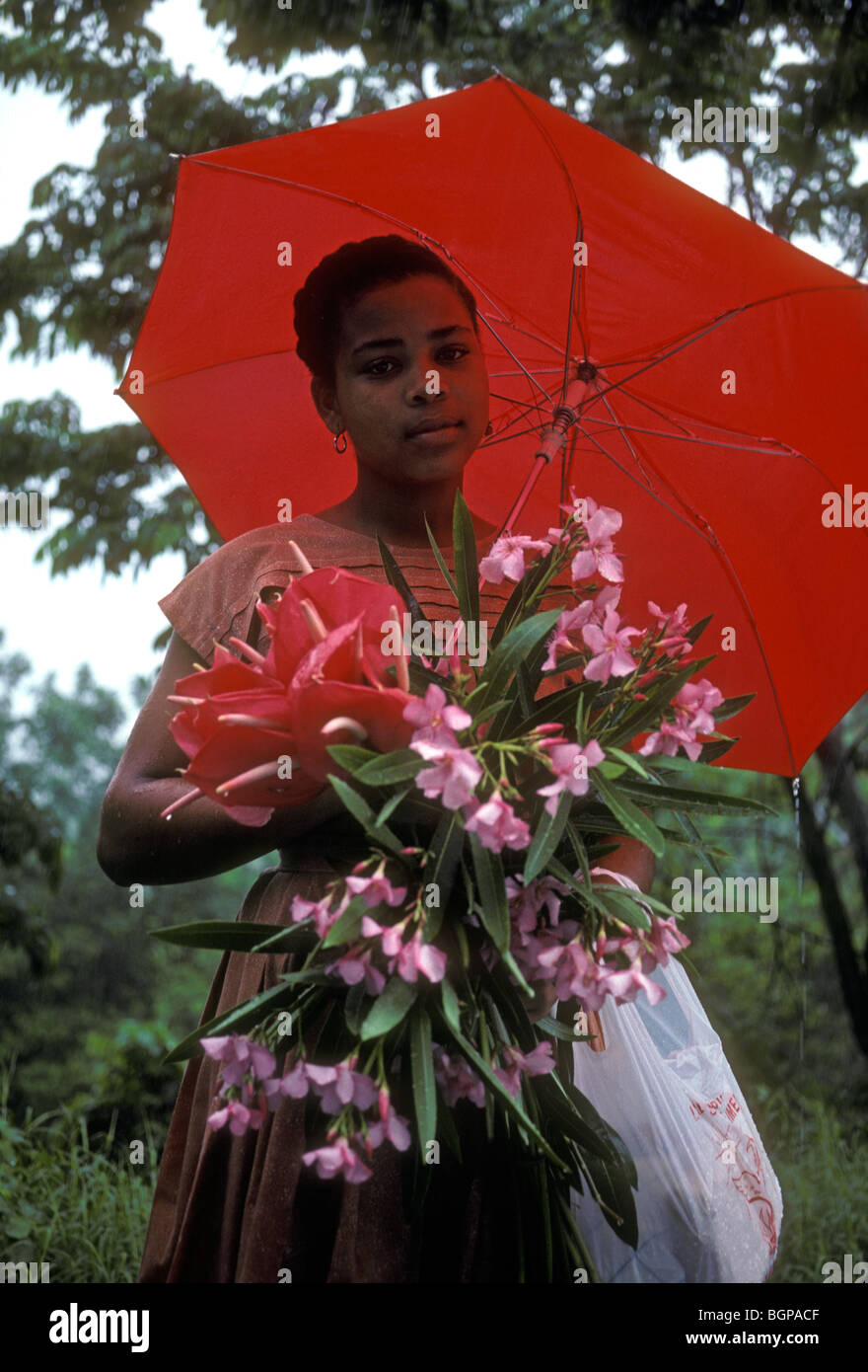 Martiniquais martiniquais, femme, femme, tenant un bouquet de fleurs, parapluie rouge, le Marin, Martinique, Antilles françaises Banque D'Images