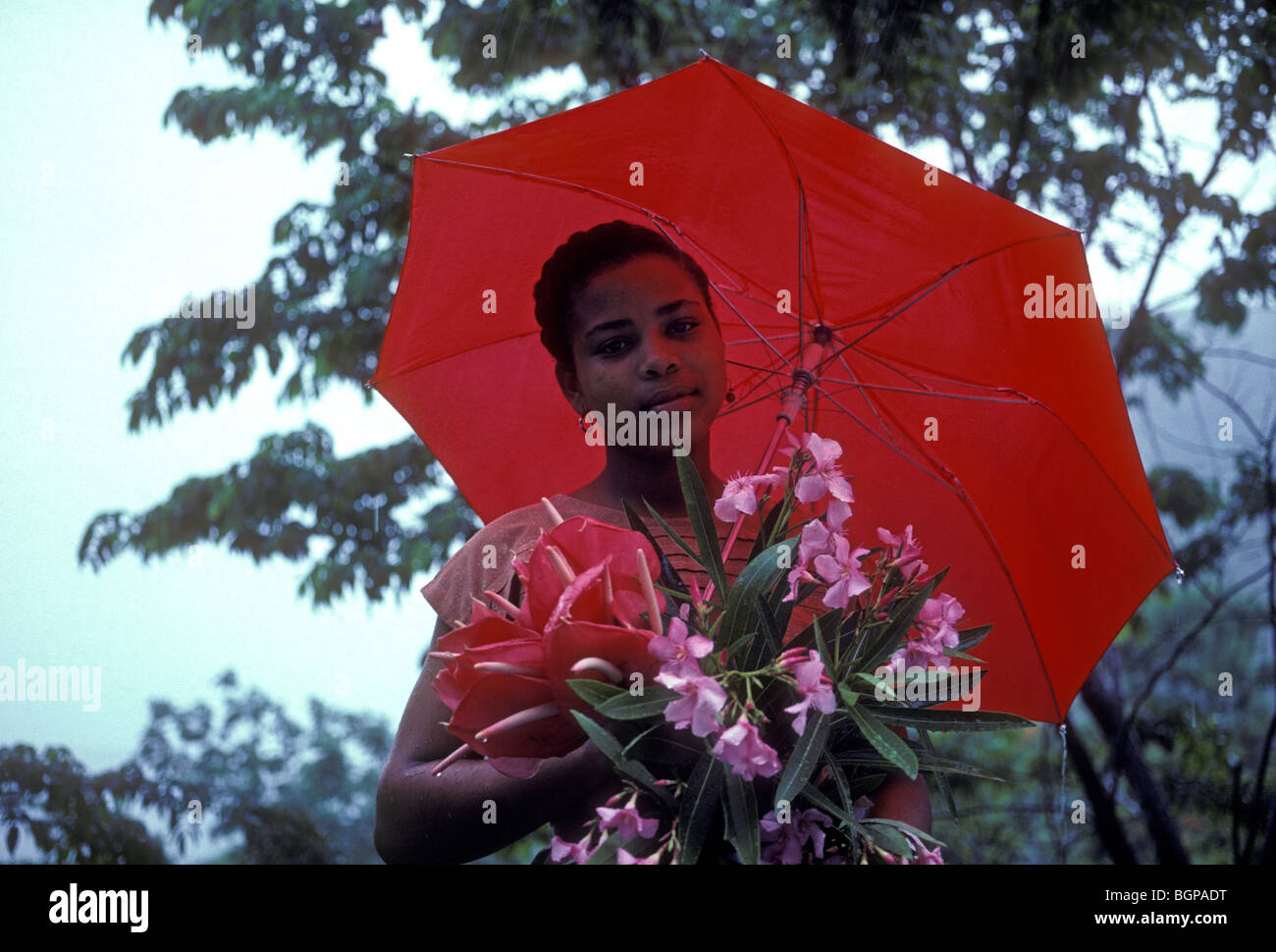 Martiniquais martiniquais, femme, femme, tenue, bouquet de fleurs, parapluie rouge, le Marin, Martinique, Antilles françaises Banque D'Images