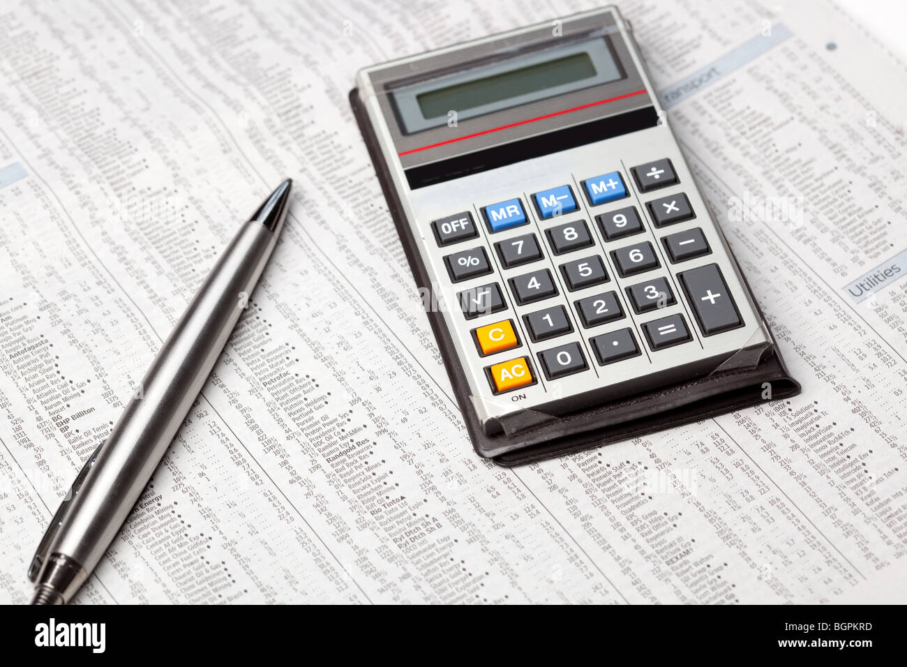 Une calculatrice et un stylo sur les stocks et d'actions page d'un journal Banque D'Images