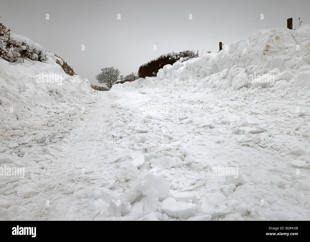 Chemin de campagne avec des amoncellements de neige. Banque D'Images
