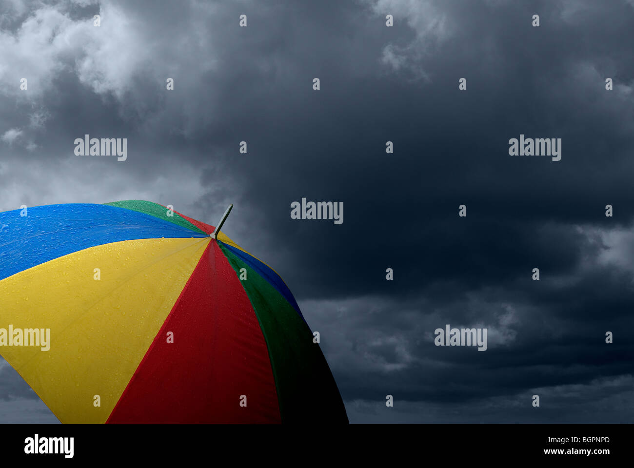 Parapluie coloré sous la pluie avec les nuages de tempête Banque D'Images Parapluie coloré sous la pluie avec les nuages de tempête Banque D'Images