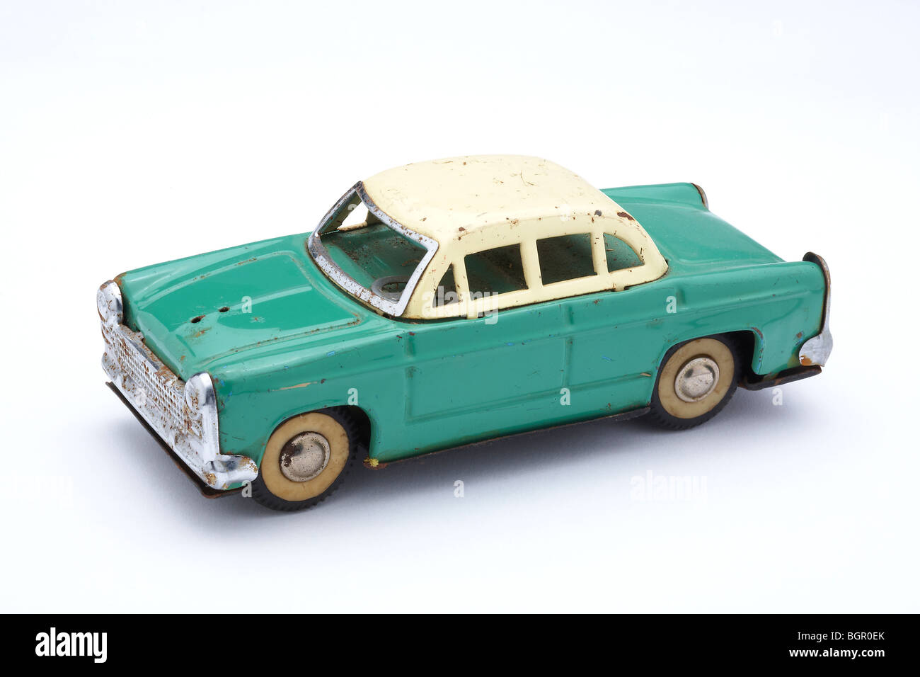 Ancienne voiture jouet étain en difficulté sur fond blanc Banque D'Images