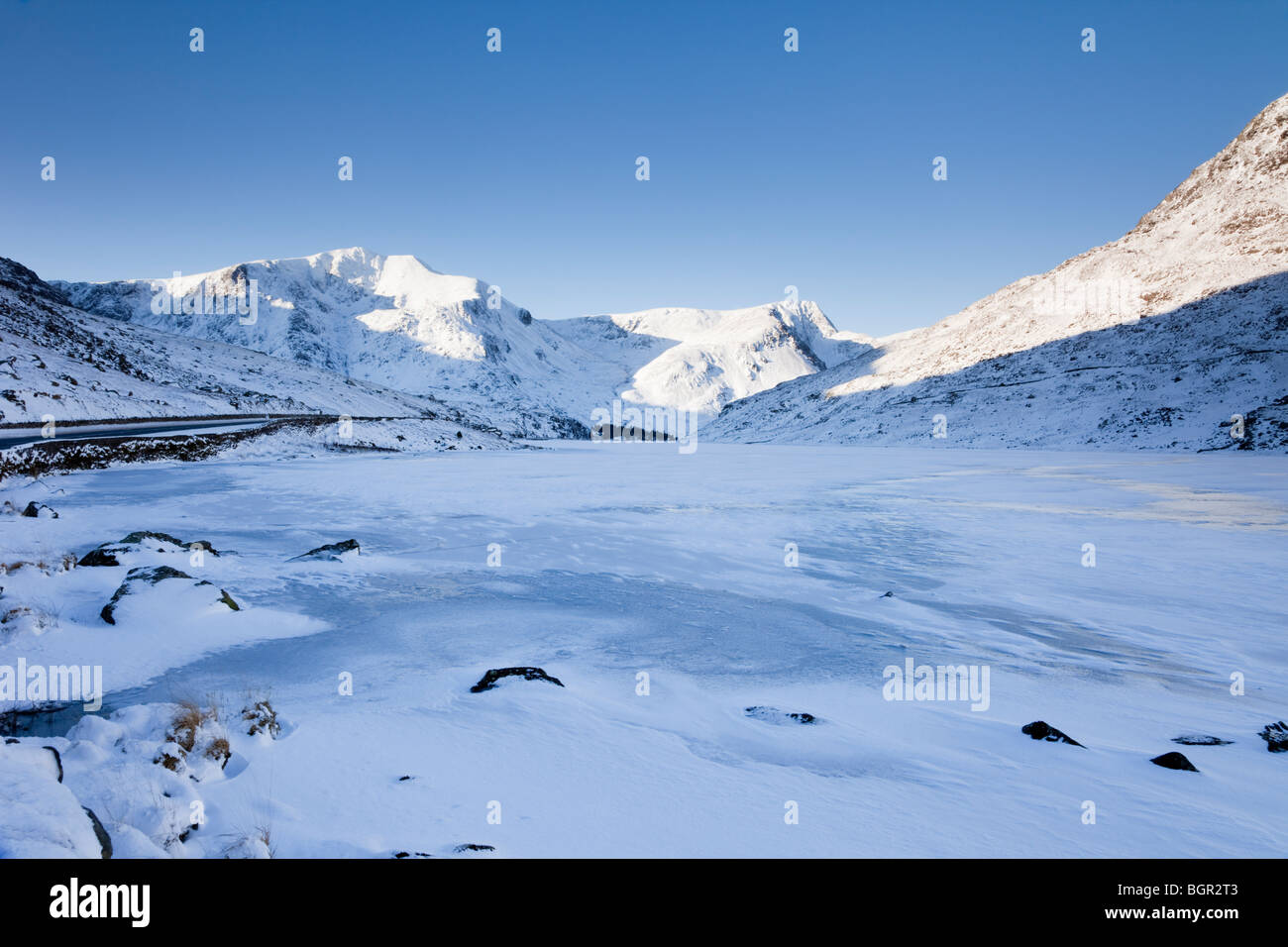 Llyn lac Ogwen congelé avec ses montagnes couvertes de neige en hiver neige profonde après Ogwen Valley, Gwynedd, au nord du Pays de Galles, Royaume-Uni, Angleterre Banque D'Images