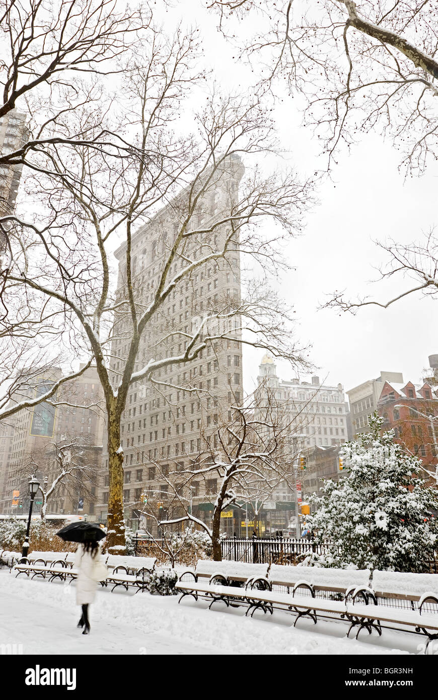 Flatiron Building hiver tempête marcher avec parapluie Banque D'Images