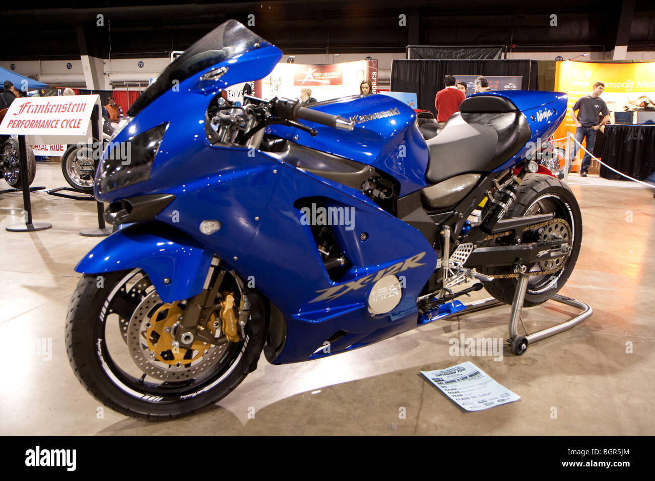 Un sport moto kawasaki bleu sur l'écran dans une salle de ventes, en attente de l'acheteur pour le prendre Banque D'Images