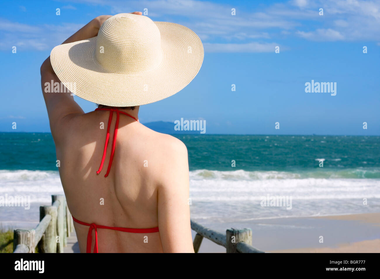 Woman with hat face à la mer sur une journée ensoleillée Banque D'Images