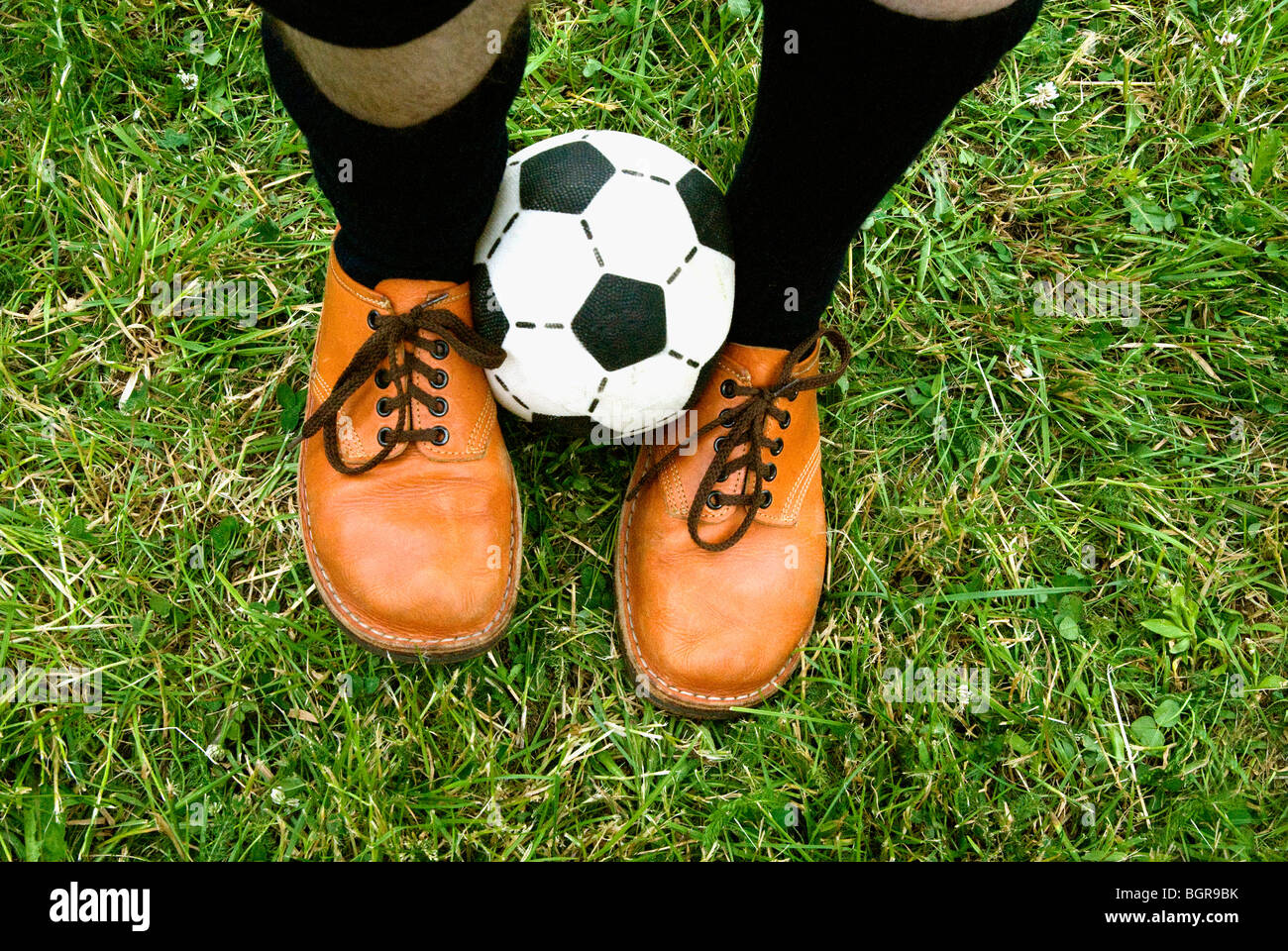 Un ballon de football entre les deux pieds. Banque D'Images