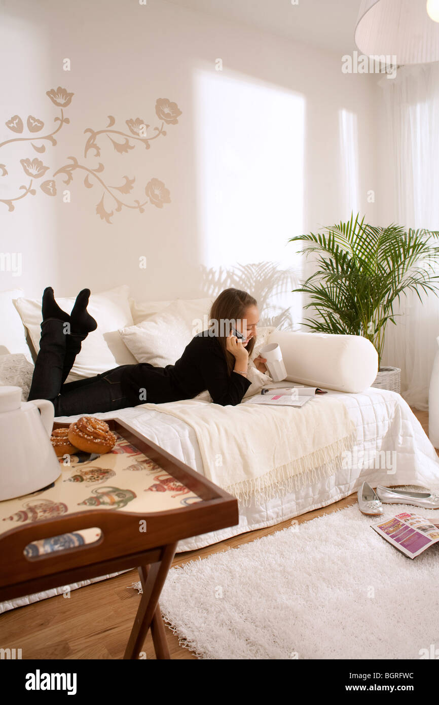 Teenage girl couché dans une table dans un style scandinave, la Suède. Banque D'Images