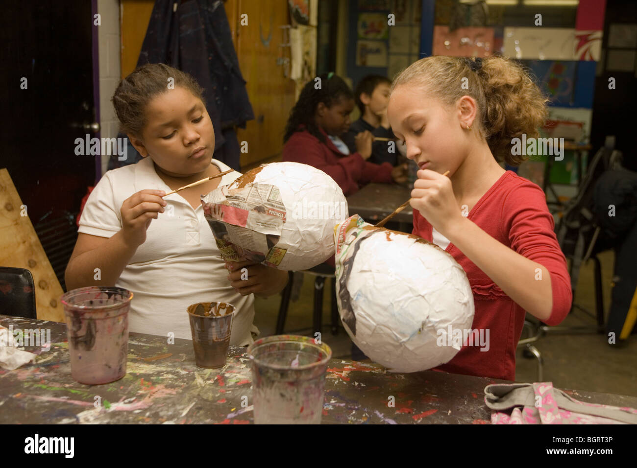 Les filles travaillent sur le papier mâché art project à un centre communautaire après l'école à Manhattan, New York City Banque D'Images