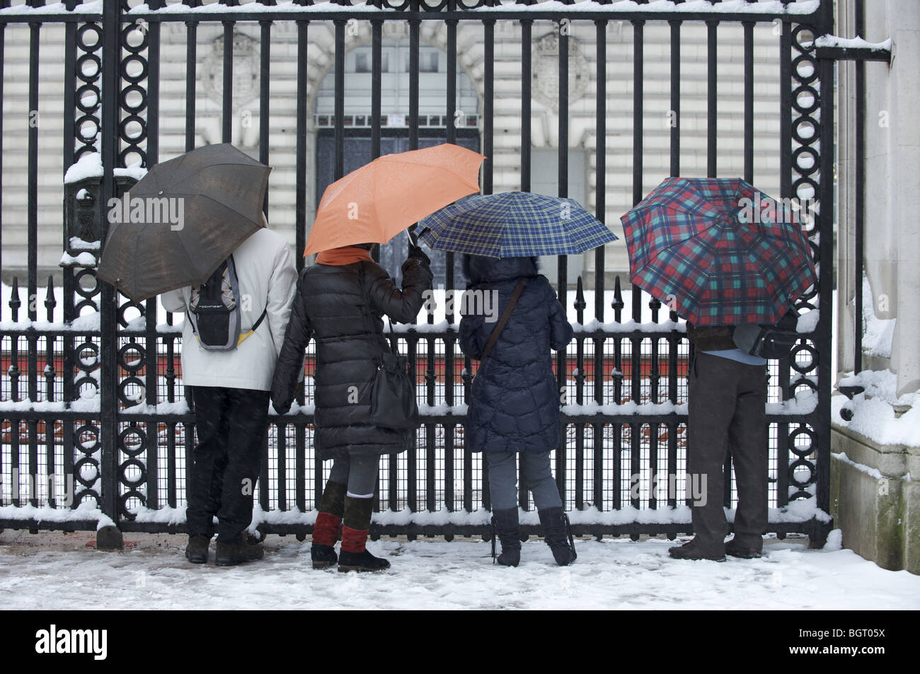 Les touristes à Buckingham Palace gates dans la neige Banque D'Images