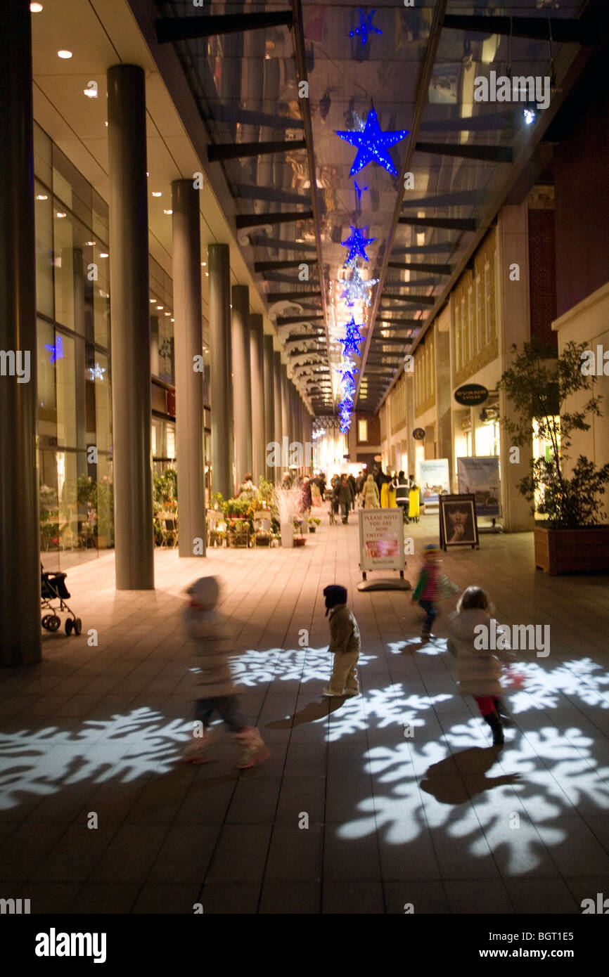 Les enfants courent le plus de lumières de Noël projeté sur la chaussée Spitalfields Londres, Angleterre, Grande-Bretagne, Royaume-Uni. Banque D'Images