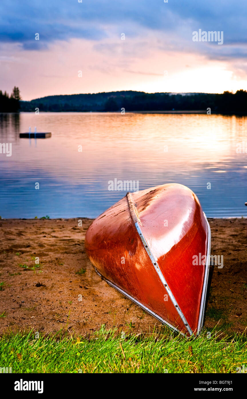 Canot sur la plage au coucher du soleil sur les rives du lac Banque D'Images